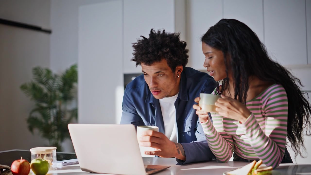 Young couple sharing coffee talking video call online standing kitchen closeup.