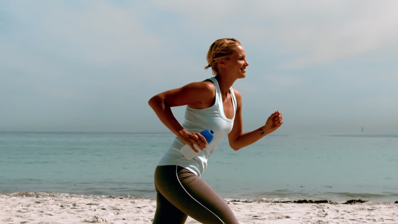 Sportiva che fa jogging in spiaggia