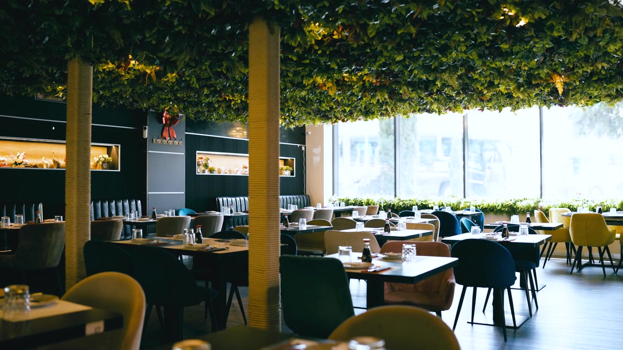 Moderne restaurantinteriør med hængende grønne planter i loftet