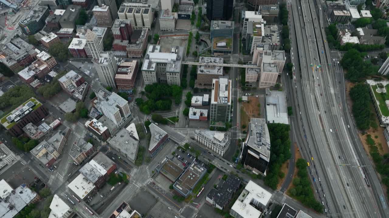 Drone shot tilting up to reveal Seattle's dense sector of skyscrapers on a cloudy day