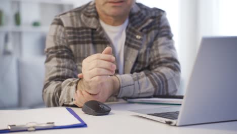 Der-Mann,-Der-Im-Homeoffice-Arbeitete,-Verletzte-Sich-Durch-Harte-Arbeit-An-Den-Handgelenken.