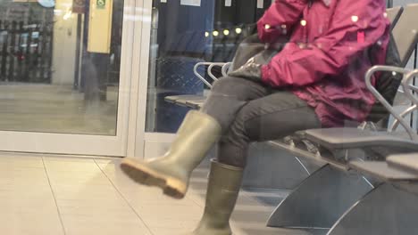 Woman-sits-in-empty-waiting-room-at-train-station