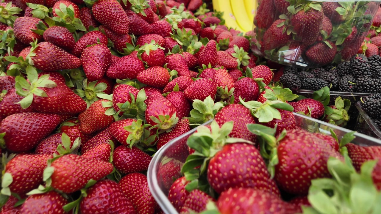 Abundant Fresh Strawberries and Mulberries at a Market