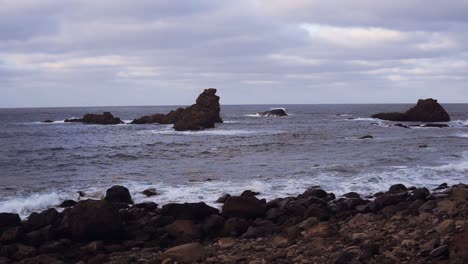 endless ocean waves crashing on pictorial grey rock with white foam in summer horizontal view. concept unspoiled nature environment. cloudy weather. slow motion