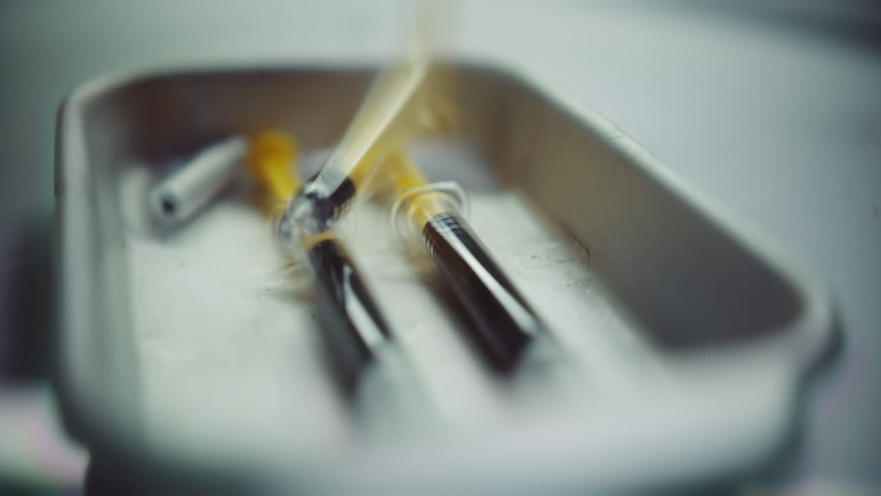 Syringes with a dark liquid on a medical tray