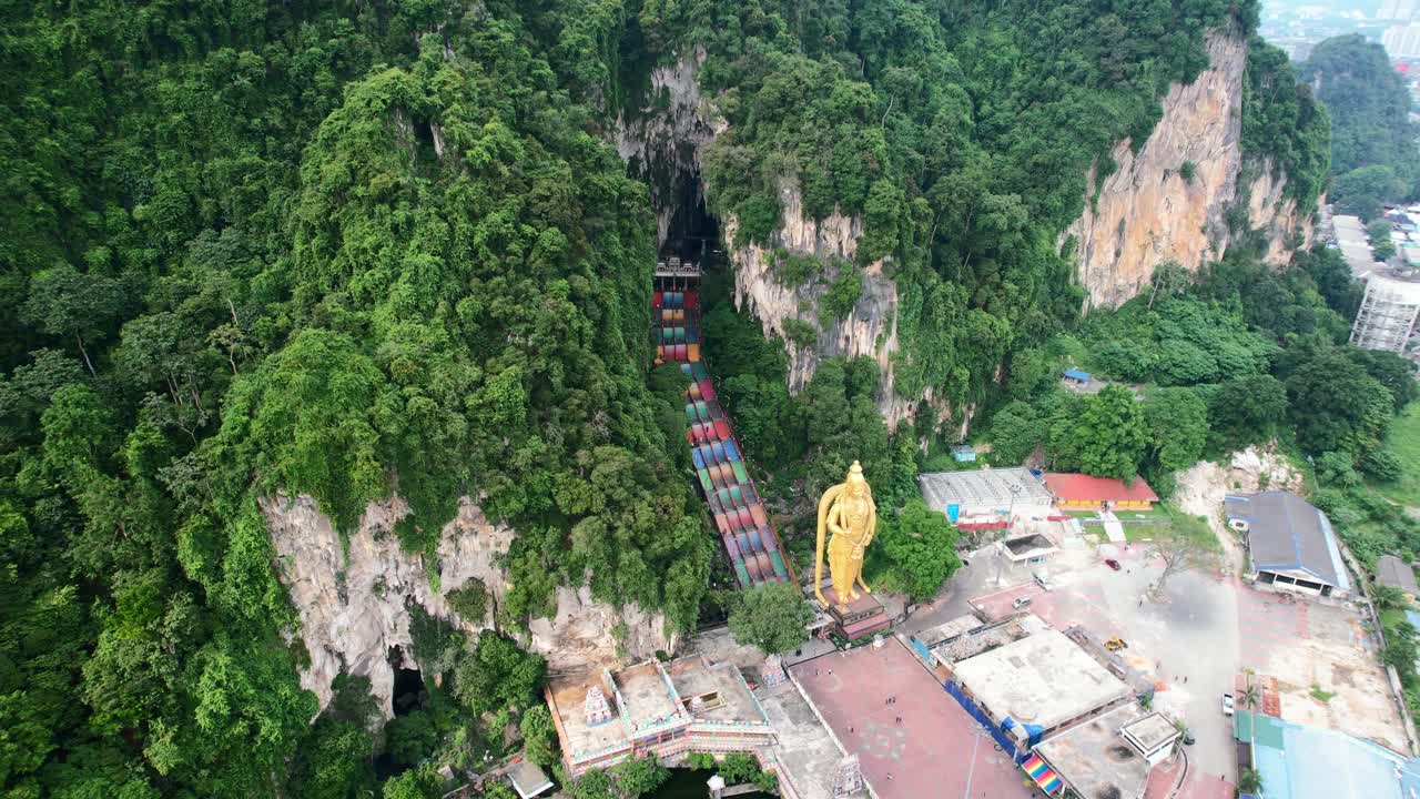 high altitude top down aerial of the colorful staircase leading to the Batu Caves and Lord Murugan Statue on a cloudy afternoon with no tourists in Kuala Lumpur Malaysia
