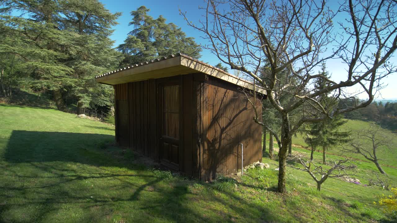 Orbital Shot Of A Small Wooden Cabin Under The Sun In The Countryside in Ard&egrave;che, France