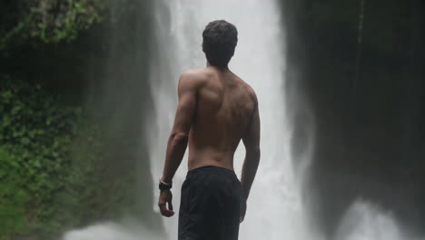 el hombre se vuelve y mira corriendo la cascada de la fortuna costa rica, cámara lenta