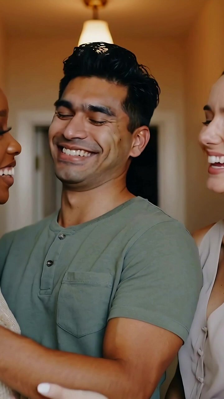 Vertical video: Camera zooming laughing man in tee amid women touching him as pals in hall pendant