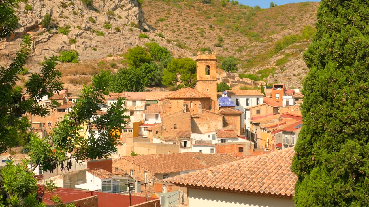 Inquadratura dall'alto di un antico e caratteristico villaggio spagnolo con torre campanaria in lontananza a Borriol, Spagna, in una giornata di sole