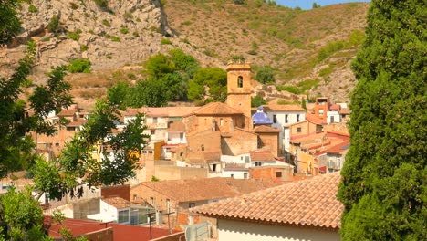 Disparo-En-ángulo-Alto-Sobre-Un-Antiguo-Pueblo-Típico-Español-Con-Torre-De-Iglesia-A-Distancia-En-Borriol,-España-En-Un-Día-Soleado