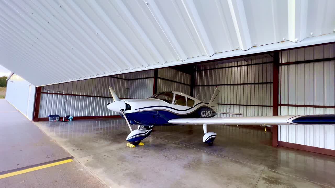 la puerta del hangar está cerrada con el piper cherokee 180 adentro.