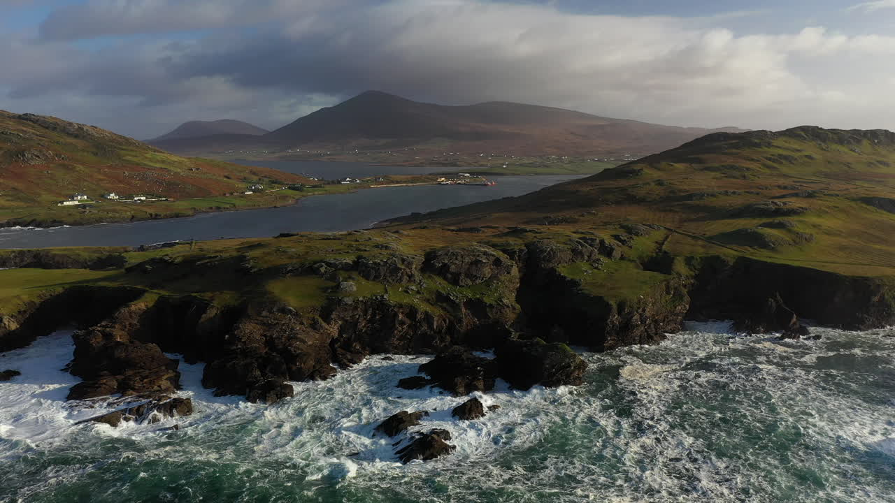 Ripresa cinematografica aerea rotante con drone delle onde dell'oceano e della costa presso le Bianche Scogliere di Ashleam sulla Wild Atlantic Way in Irlanda.