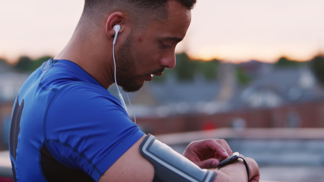 Male runner sets app on smartwatch in street and starts run