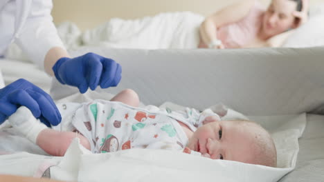 doctor changing a newborn's diaper