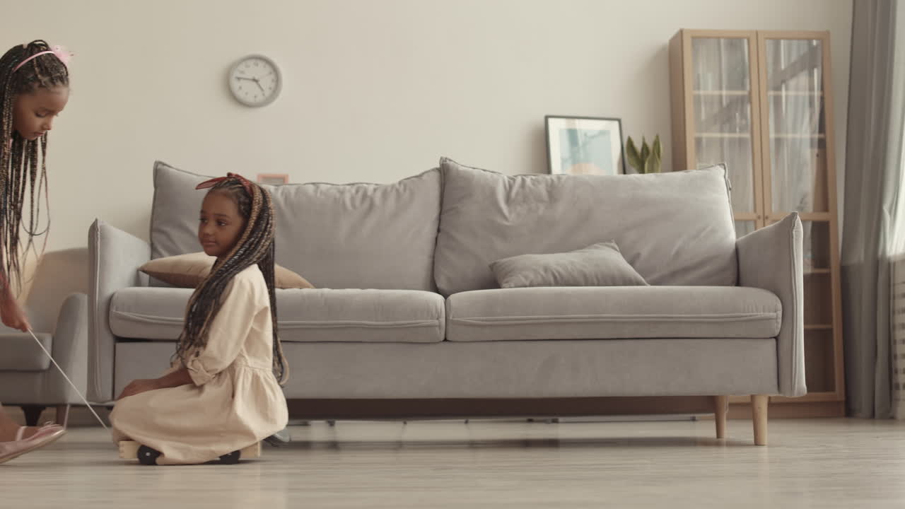Girl Riding Sister on Toy Dolly