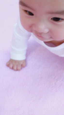 asian baby crawling on blanket