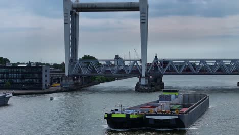 background of spoorbrug over de oude maas a container barge and speedboat travel