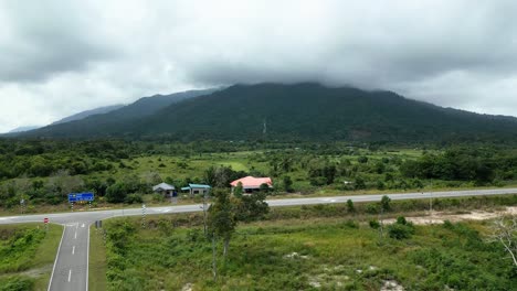 vista aérea del pueblo de pueh, con el campo de arroz y la montaña de fondo, sarawak, borneo,