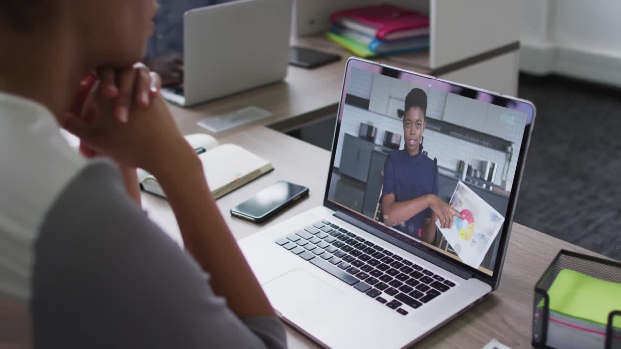 Mid section of african american woman having a video call with female colleague on laptop at office