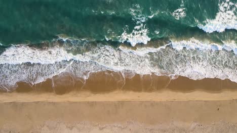 aerial drone shot of dhanushkodi’s deserted stretches, framed by shimmering waters on both sides.