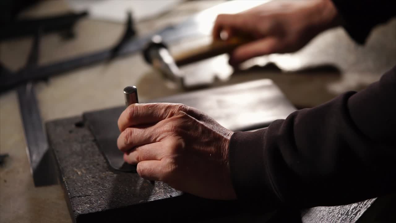 Metalarbejder bruger stanseværktøj på metalplade