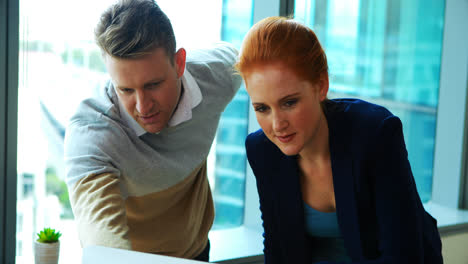 executives discussing over laptop