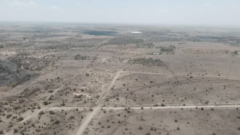 An-aerial-view-of-dry-river-and-shrubs-covering-a-desert-landscape