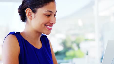 Woman-smiling-and-using-laptop