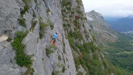 close drone footage of a man stopped while climbing in the pyrenees moutains at tarascon sur ariège