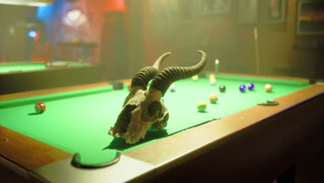 unique pool table setup featuring a horned skull in a dimly lit bar