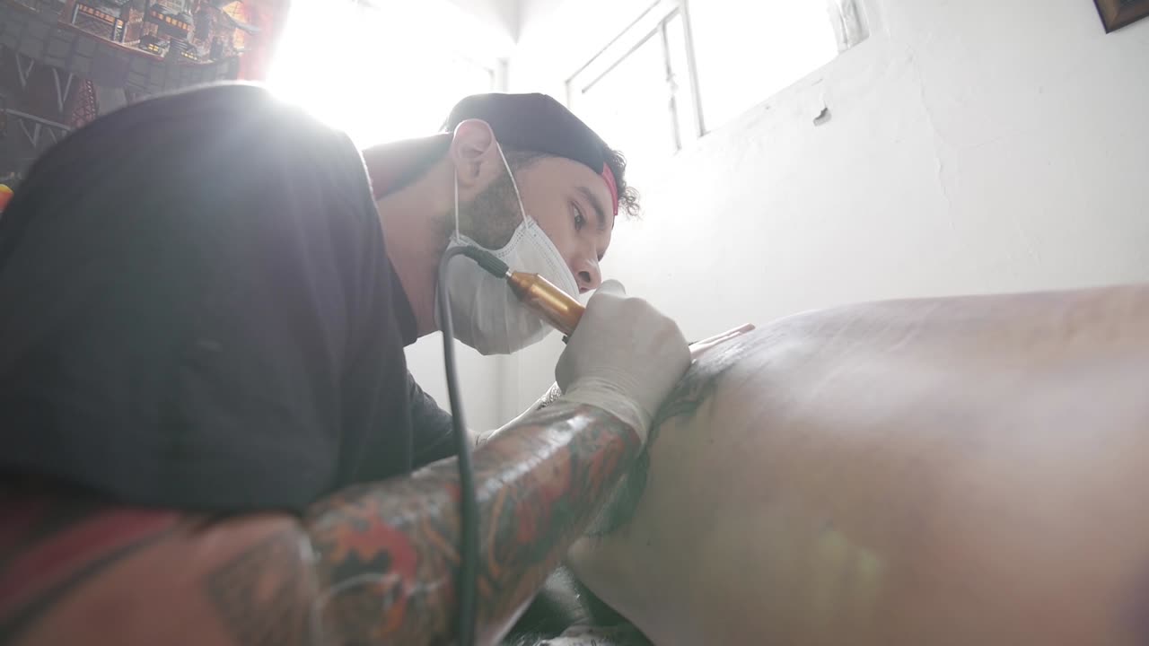 Tattoo artist shot with sun flaring trough the window