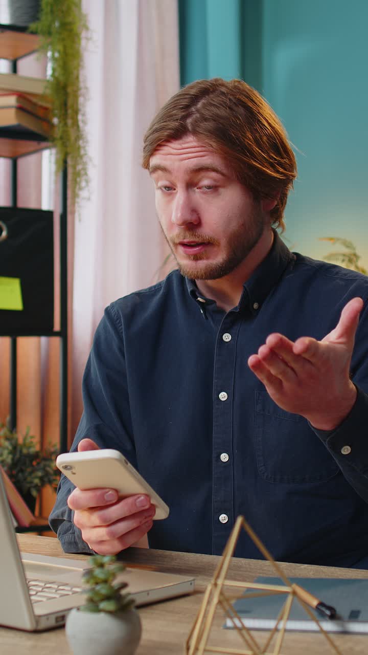 Uomo d'affari sorridente che utilizza un'app per smartphone online e indica un pollice in su a distanza per un lavoro da remoto