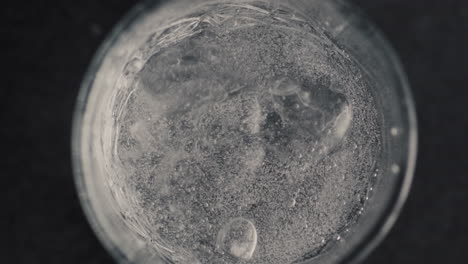 agua mineral fría con cubo de hielo de primer plano. concepto de proceso de elaboración de cócteles