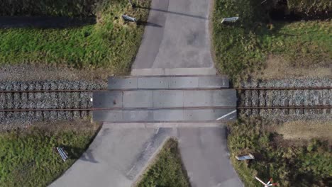 Multiple-drone-shots-of-railroad-with-crossing-through-nature