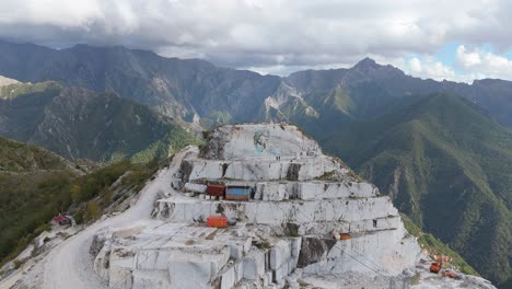 una cantera de mármol en los alpes de apuán con maquinaria y bloques de piedra cortados, vista aérea