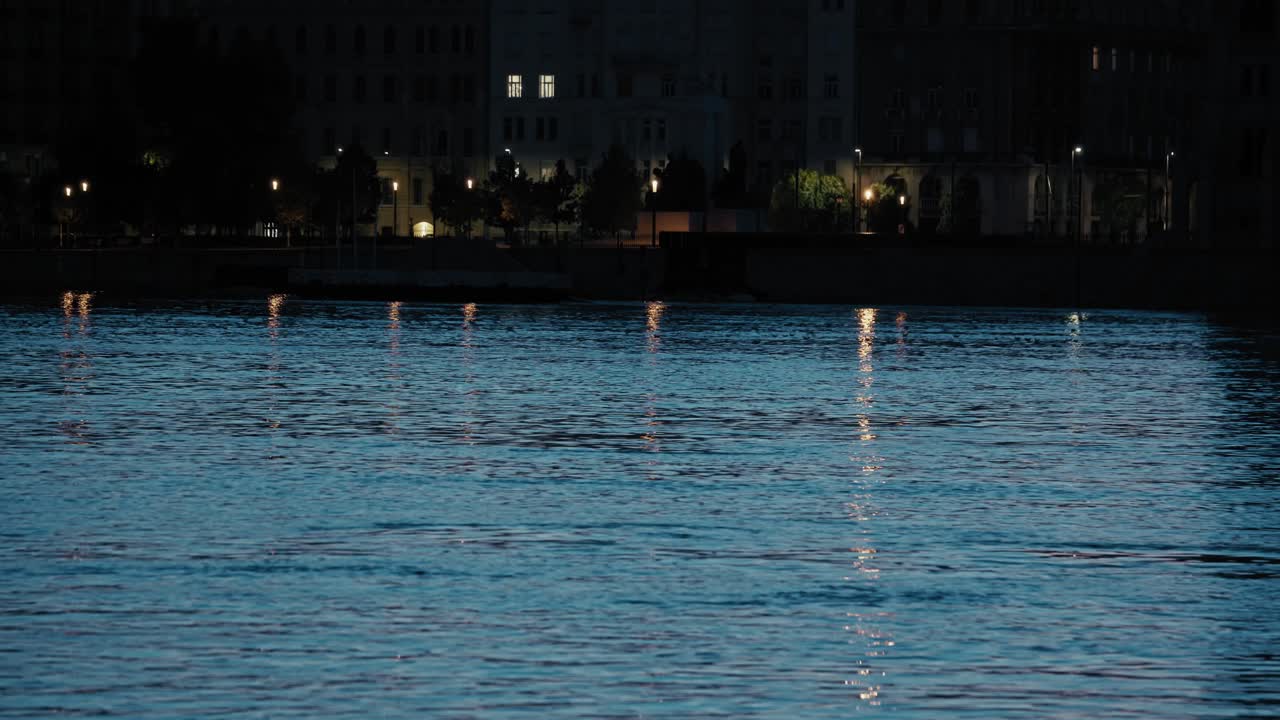 Nighttime reflections of city lights on the river during the 2024 flood in Budapest, Hungary