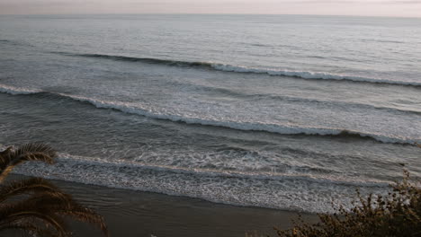 Una-Vista-De-Las-Olas-Del-Océano-Durante-La-Puesta-De-Sol-En-La-Playa-Swamis-En-Encinitas,-California