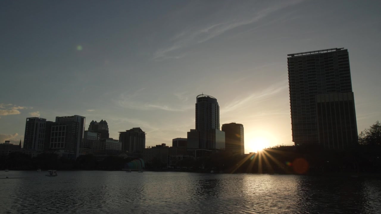 Lake Eola Park en Orlando, Florida, al atardecer. El sol está a punto de ocultarse tras los edificios