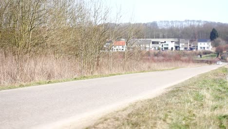 Old-sports-car-driving-fast-over-a-small-road-in-the-countryside