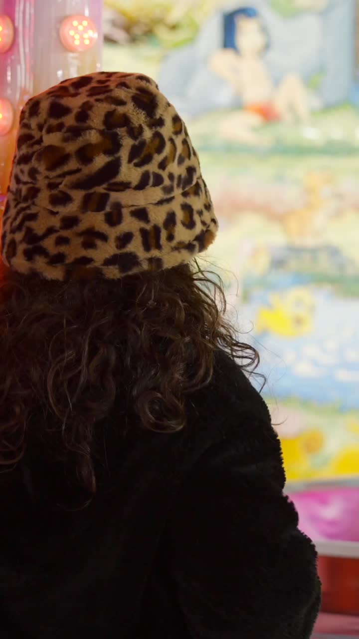 Person with a leopard print hat at an amusement park