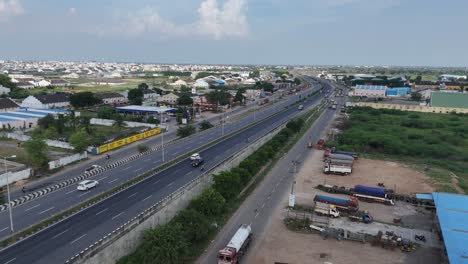 serene rural scenes of amaravathi, vijayawada, with a highway cutting through green farmlands with building near by.