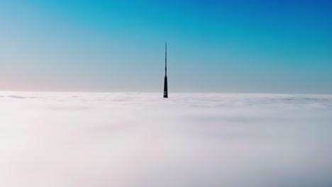cinematic morning drone shot shows riga’s iconic tv tower standing above clouds