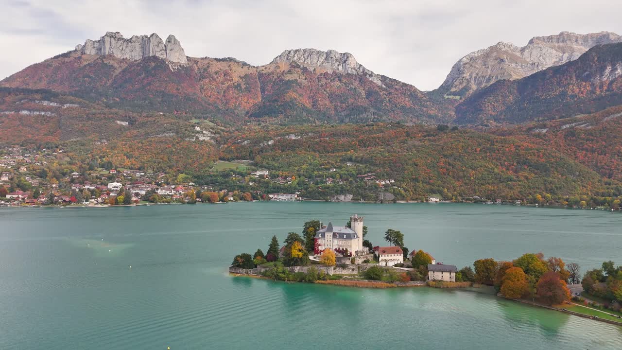 Château de Duingt projecting into Lake Annecy with the Bauges and Bornes Massif mountains rising in the background, near the village of Duingt in Haute‑Savoie, Auvergne‑Rhône‑Alpes, France, aerial