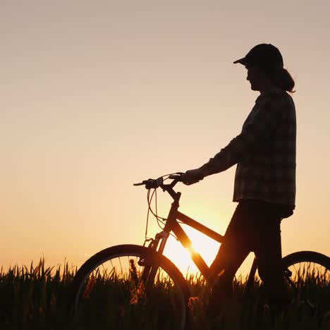 woman with bike admires sunset 1