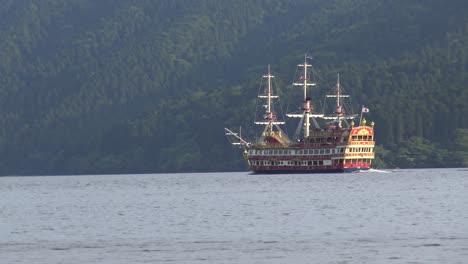 timelapse, close-up, the view of traditional japanese ship enters right to the picture in ashi lake