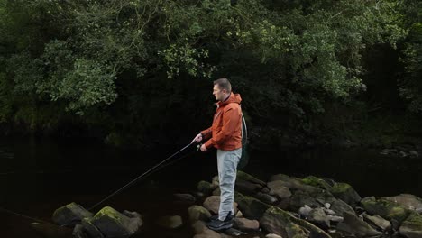 Toma-Manual-De-Un-Pescador-Lanzando-Su-Señuelo-Giratorio-A-Un-Arroyo.