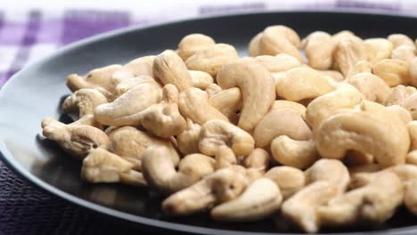 pile of cashews on a black plate