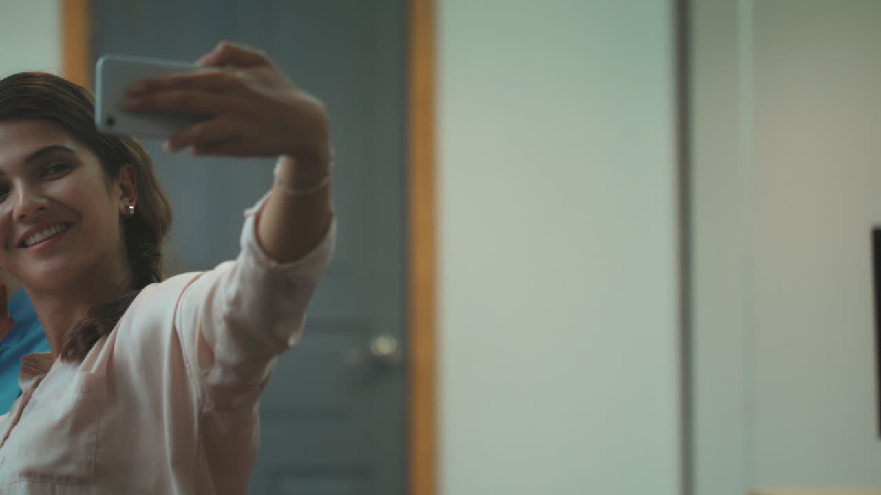 trabajadores sonrientes tomando selfies en el coworking. equipo feliz haciendo el símbolo de la victoria.