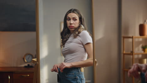 Woman trying on jeans in front of a mirror